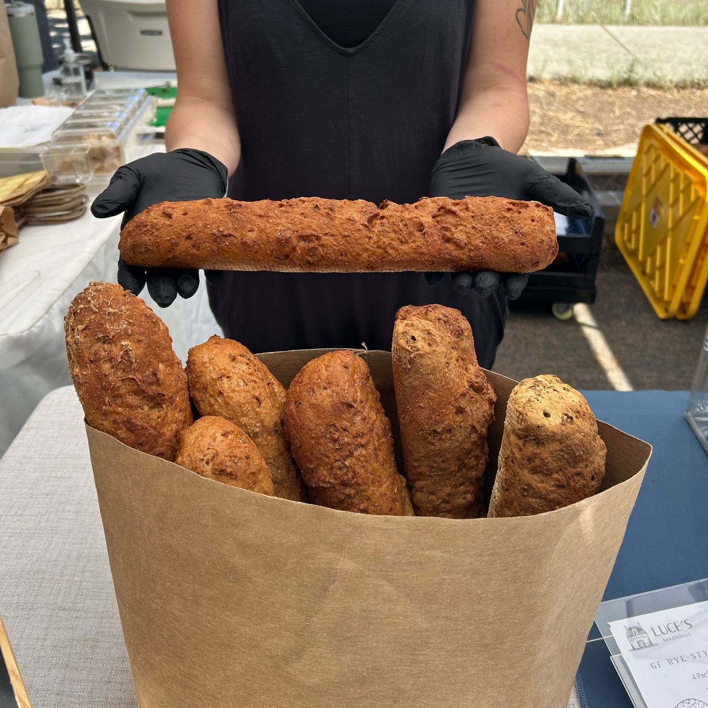 Person holding a bag of bread sticks outdoors